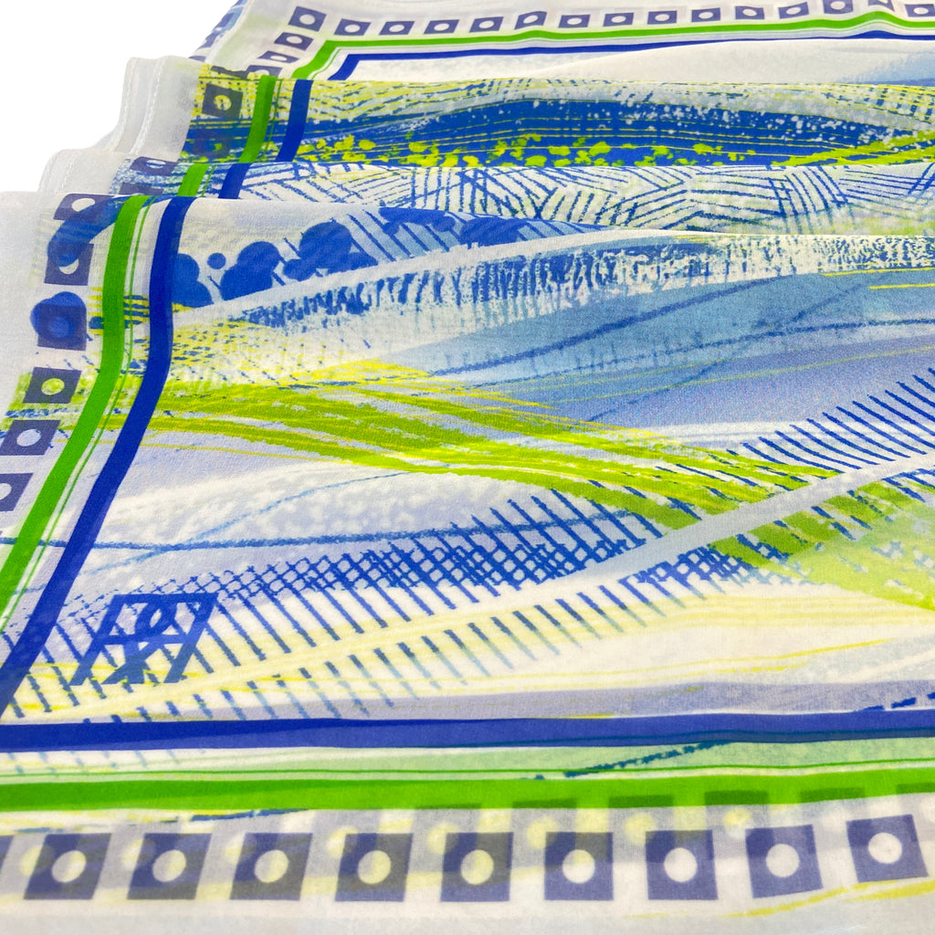 Close-up of a colorful silk georgette  scarf with blue, green, and white patterns.